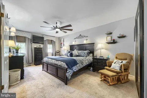 a spacious bedroom with a bed and a chandelier