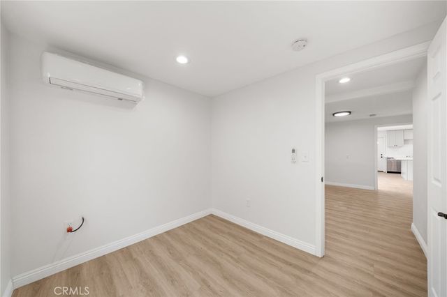 a view of a room with wooden floor and a bathroom