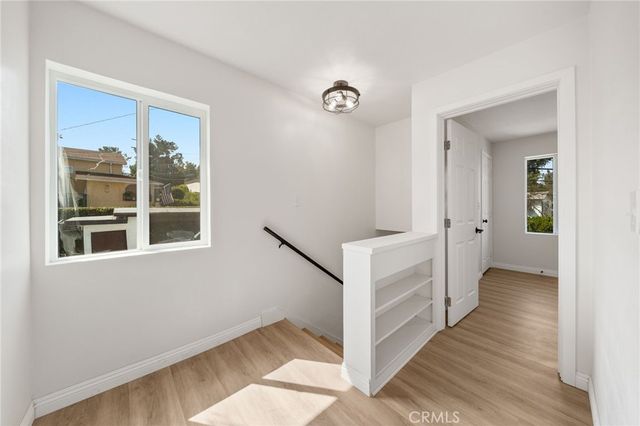 a view of a hallway with wooden floor and entryway