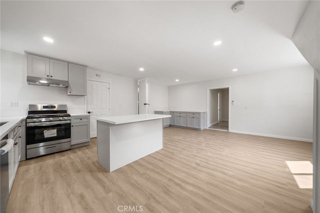 a large kitchen with stainless steel appliances kitchen island granite countertop a stove a sink and a refrigerator