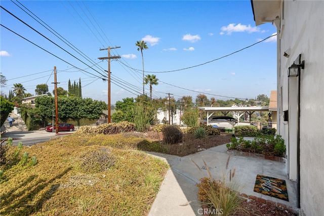 a view of a balcony with yard and potted plants