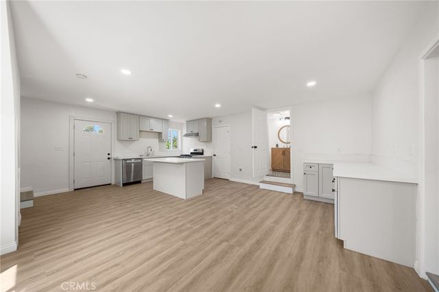 a view of a kitchen with wooden floor and a sink