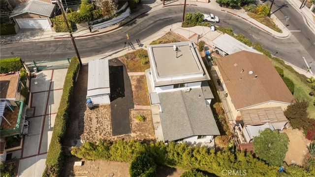 an aerial view of a house with garden space and parking