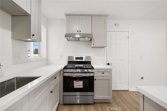 a kitchen with stainless steel appliances white cabinets and a stove a sink