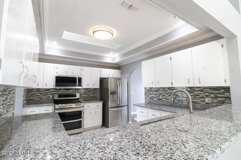 3955 Southwest 139th St Road Ocala, FL 34473 - Photo 26 of 45 a kitchen with stainless steel appliances a stove a sink and a microwave