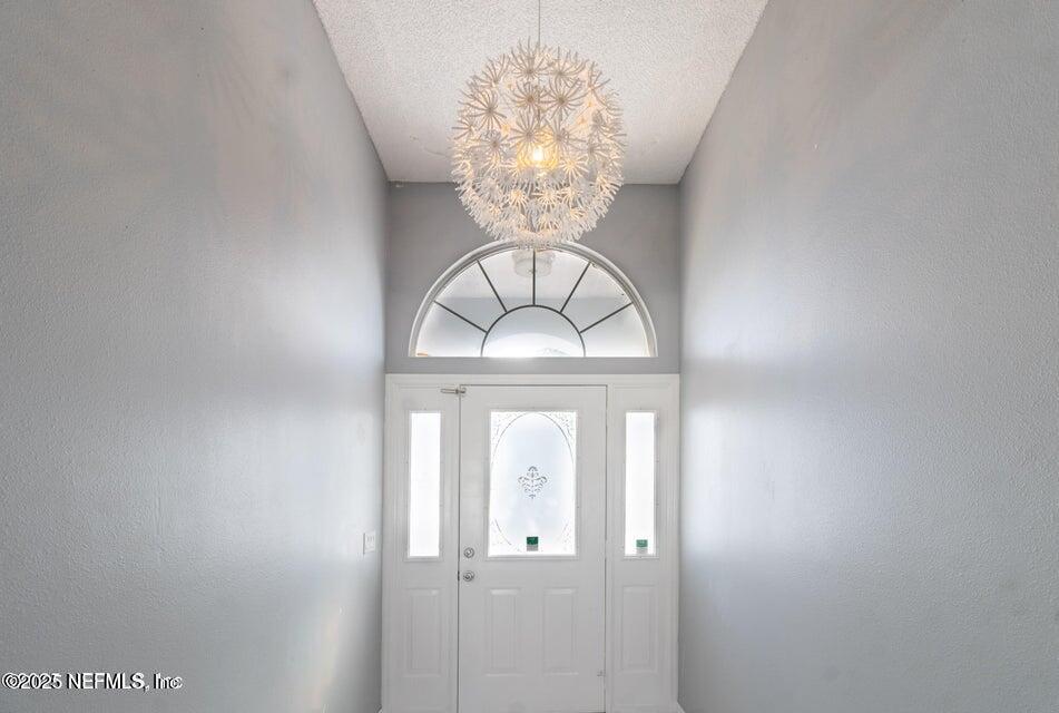 3955 Southwest 139th St Road Ocala, FL 34473 - Photo 33 of 45 a view of a hallway with a chandelier fan and a window