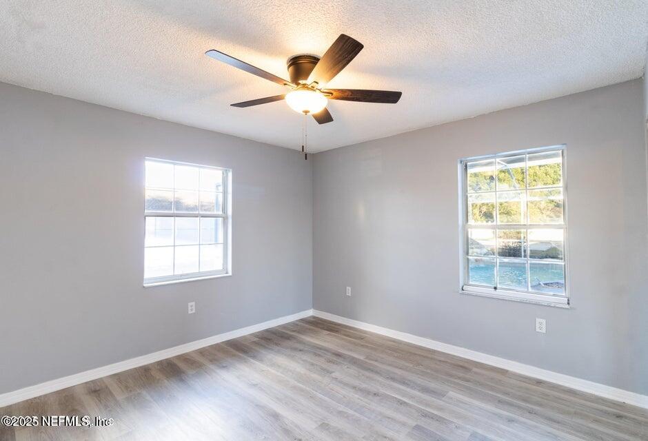 3955 Southwest 139th St Road Ocala, FL 34473 - Photo 36 of 45 an empty room with wooden floor fan and windows