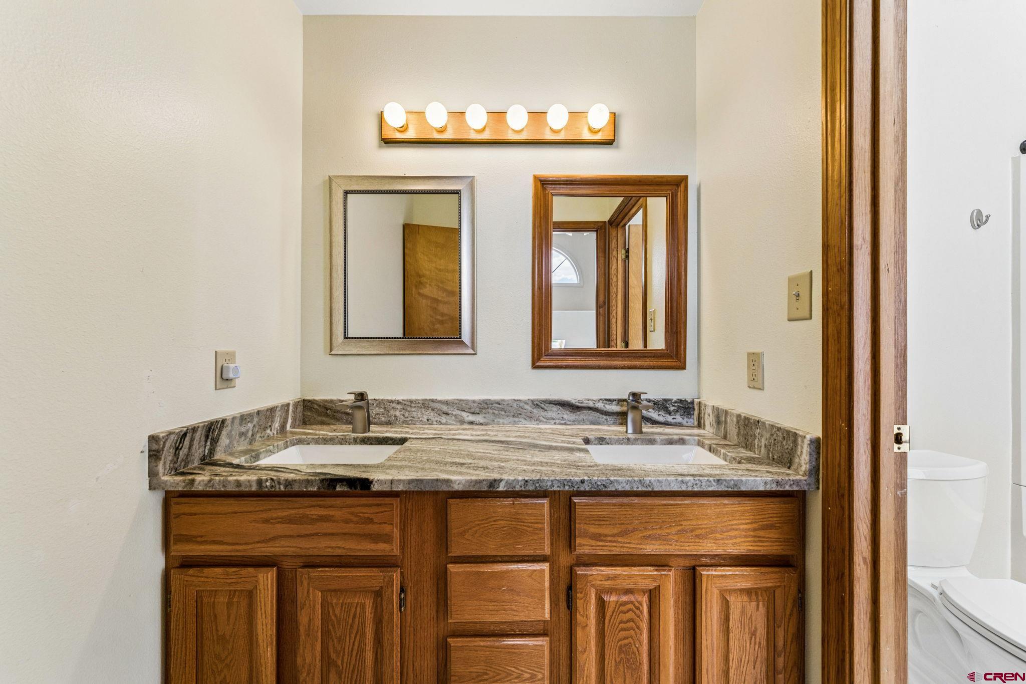 22480 Rd L Cortez, CO 81321 - Photo 19 of 44 a bathroom with a granite countertop sink and a mirror