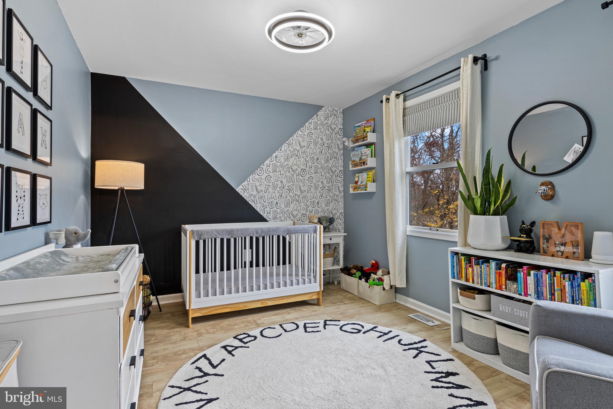 649 Niblick Lane, Unit 20 Wallingford, PA 19086 - Photo 22 of 35 a living room with baby crib and a book shelf