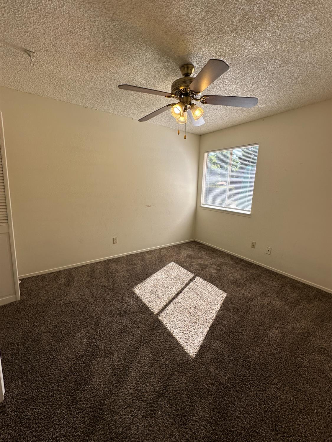 91 O Street Sanger, CA 93657 - Photo 14 of 21 an empty room with a ceiling fan and carpet