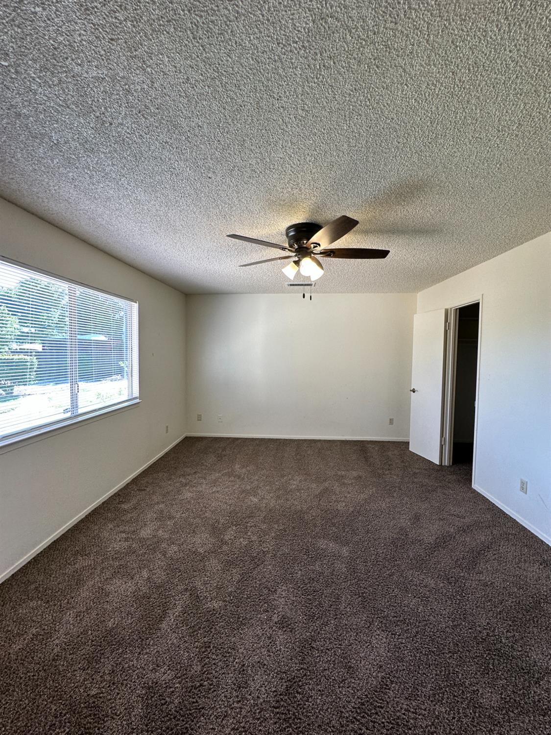 91 O Street Sanger, CA 93657 - Photo 17 of 21 en empty room with windows and ceiling fan view