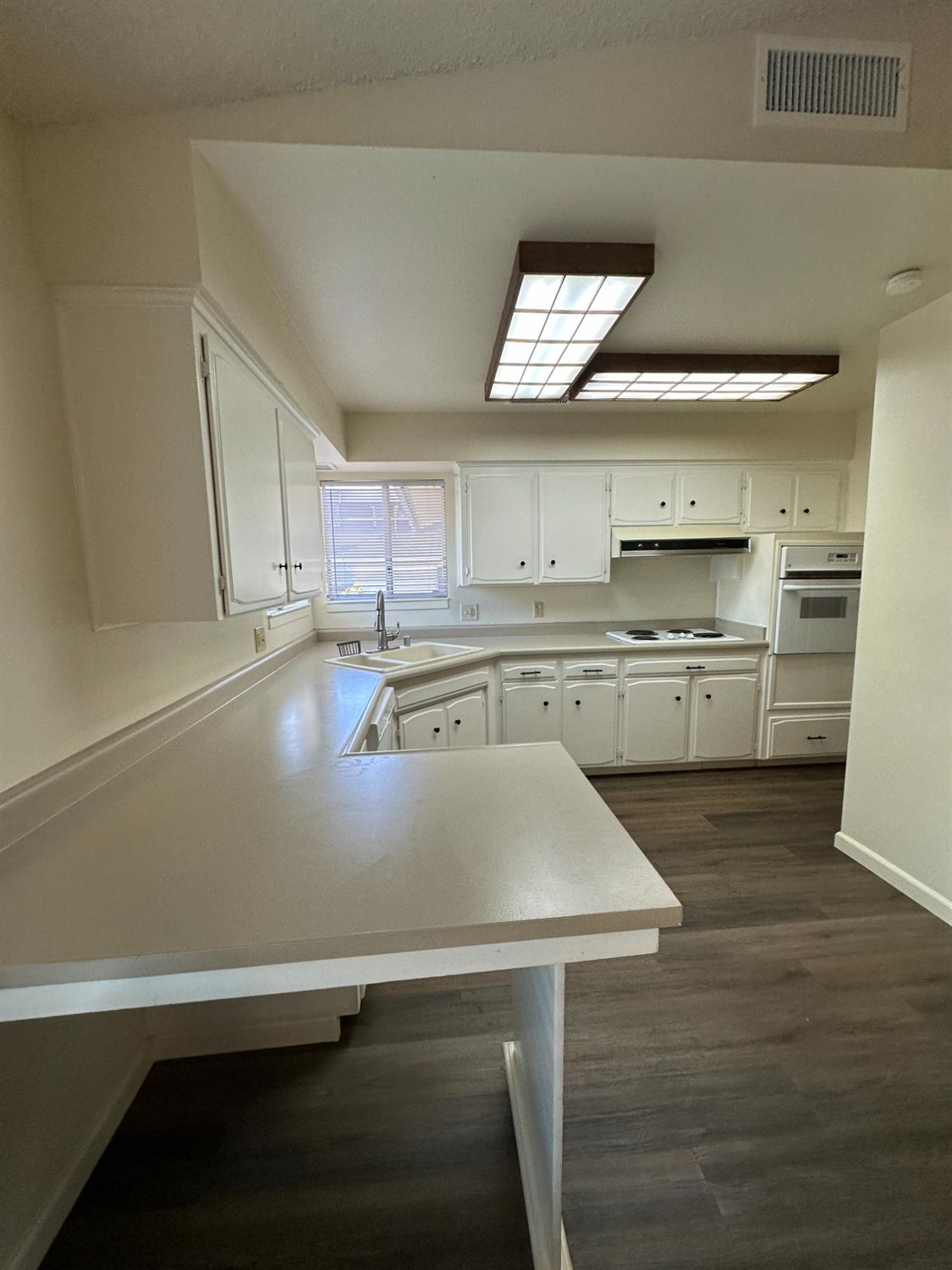 91 O Street Sanger, CA 93657 - Photo 8 of 21 a kitchen with kitchen island a sink a stove and a refrigerator