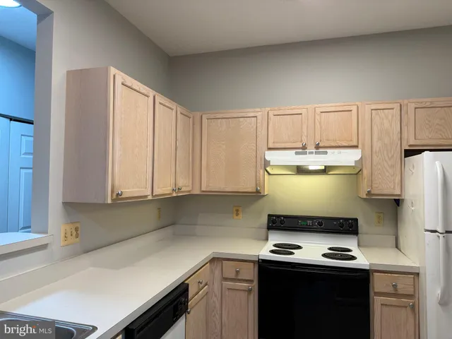 a kitchen with a stove and a white cabinets