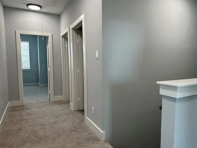 a view of a hallway with closet and bathroom