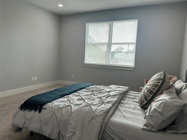 a bed sitting in a bedroom next to a window