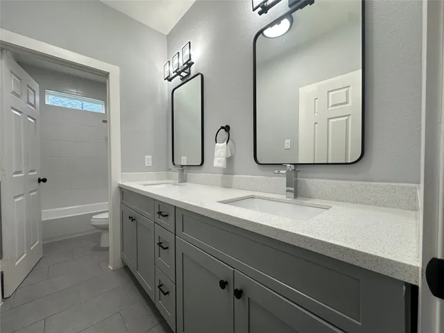 a bathroom with a double vanity sink double mirror and bathtub