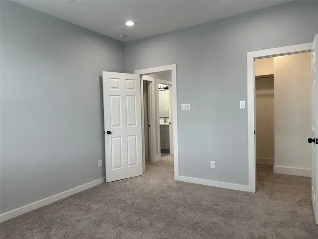 an empty room with closet and wooden door