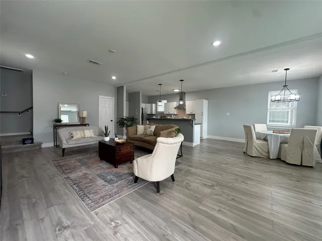 a living room with furniture and a wooden floor