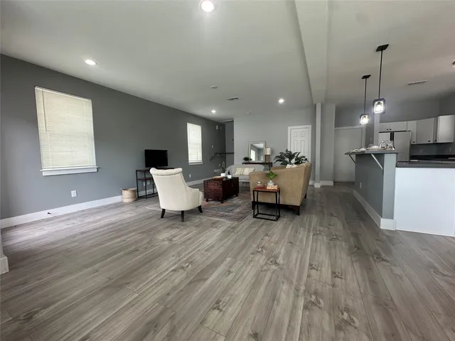 a living room with furniture and kitchen view