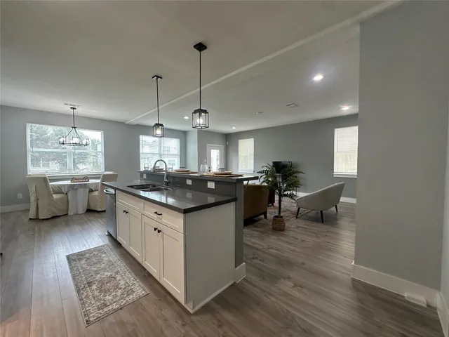 a kitchen with stainless steel appliances granite countertop a sink stove and wooden floor