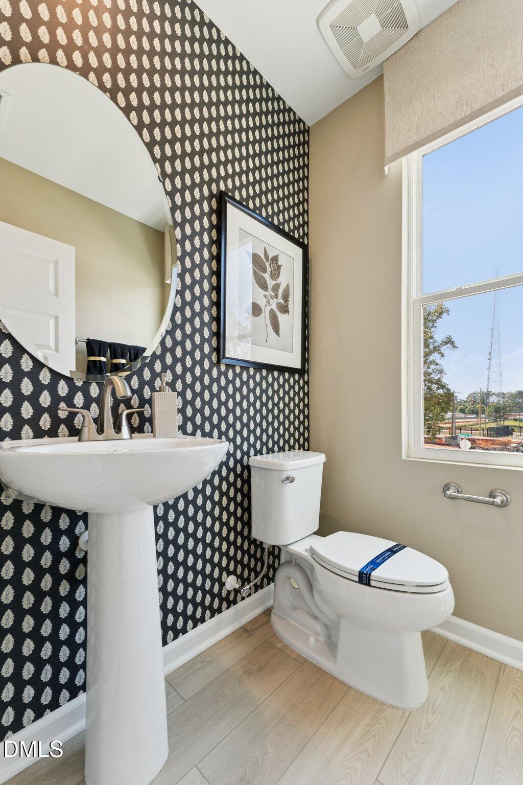 3304 Bomore Road Raleigh, NC 27610 - Photo 16 of 34 a bathroom with a sink a toilet and mirror