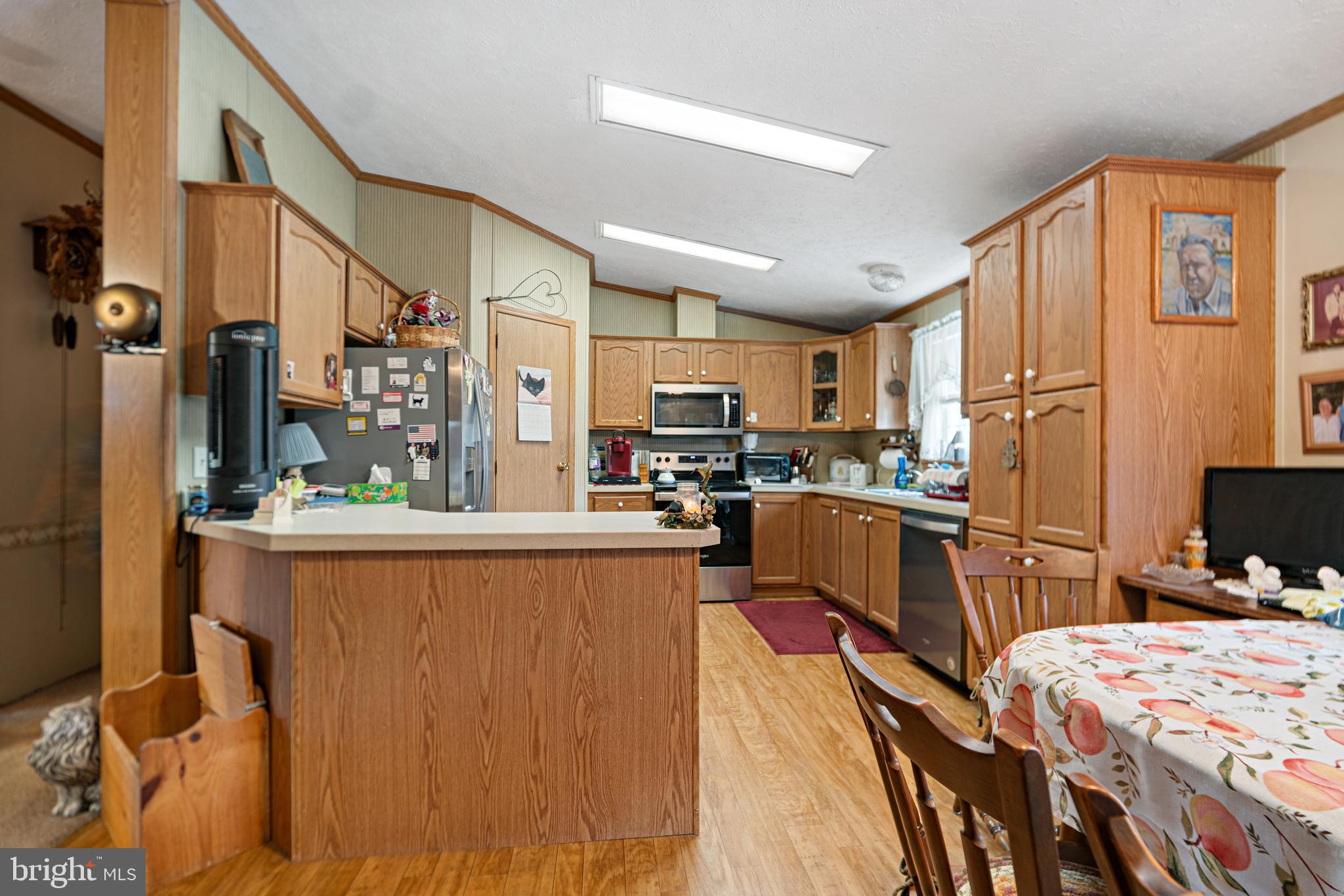 701 Cassel Road, Unit 107 Manchester, PA 17345 - Photo 6 of 21 a kitchen with stainless steel appliances granite countertop a refrigerator a stove top oven a sink dishwasher and white cabinets with wooden floor