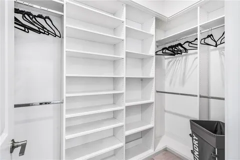 a view of walk in closet with empty racks