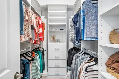 a view of walk in closet with clothes and shoes