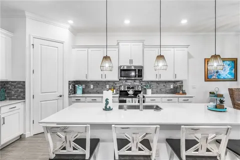 a kitchen with a table chairs stove and cabinets