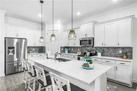 a kitchen with a sink a stove and chairs