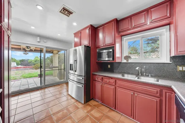 a kitchen with stainless steel appliances granite countertop a refrigerator and a sink