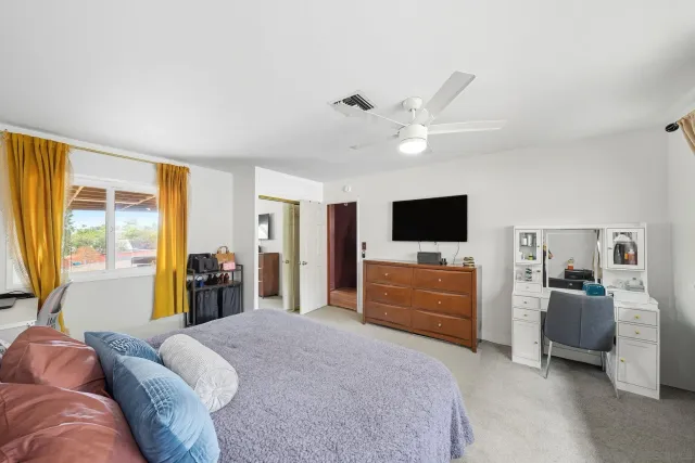 a bedroom with furniture and a flat screen tv