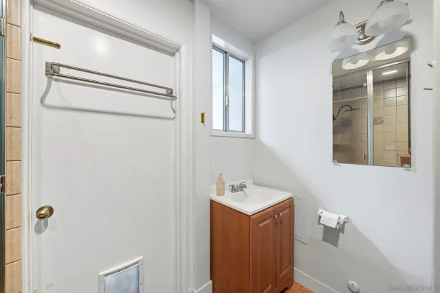 a bathroom with a bathtub shower sink vanity and mirror