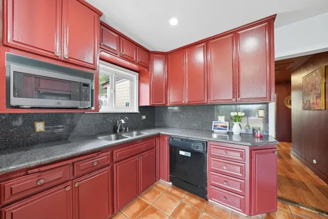 a kitchen with granite countertop cabinets stainless steel appliances a sink and wooden floor