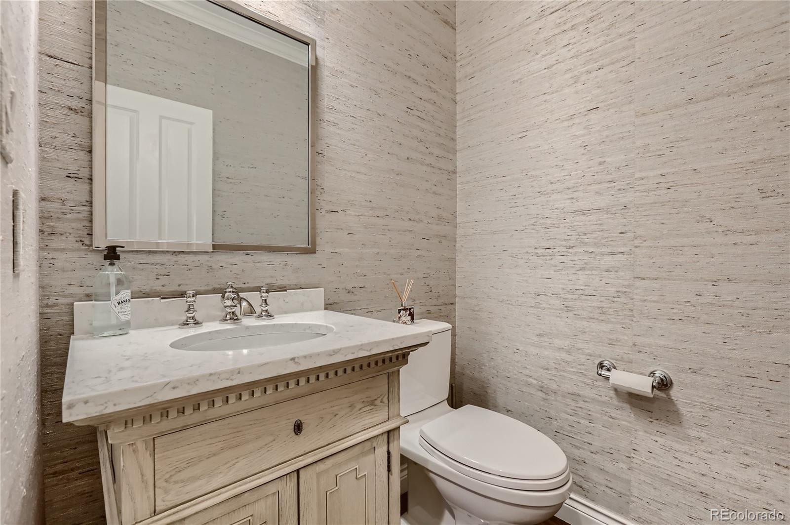 445 Jackson Street Denver, CO 80206 - Photo 13 of 29 a bathroom with a granite countertop toilet sink and mirror