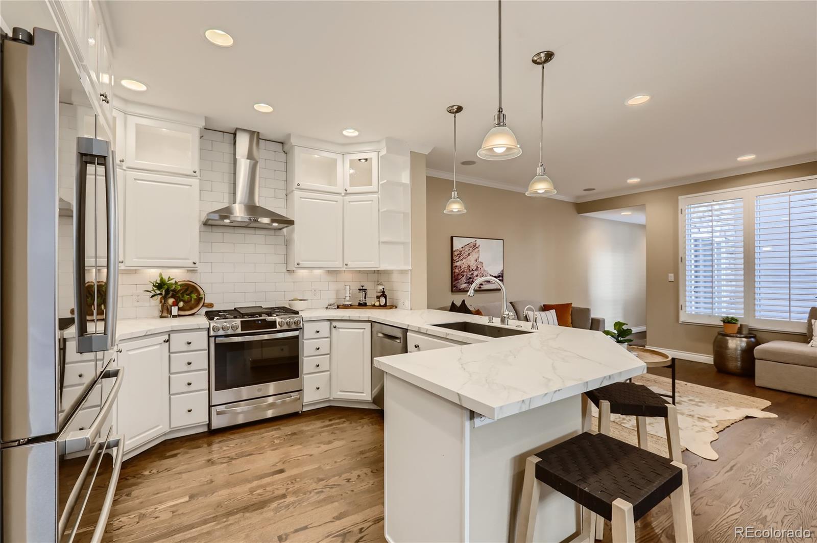 445 Jackson Street Denver, CO 80206 - Photo 5 of 29 a kitchen with a stove a refrigerator and a dining table