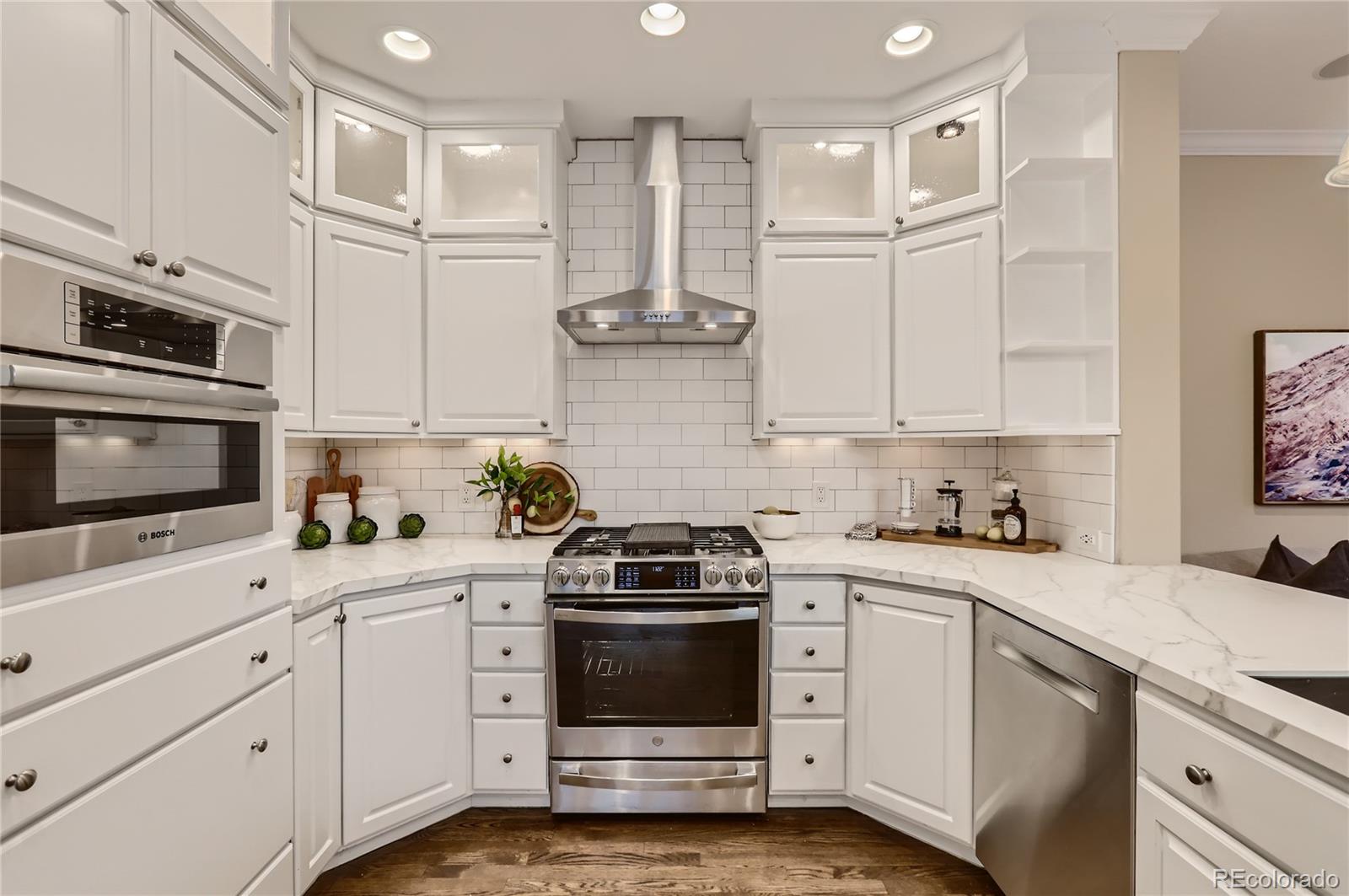 445 Jackson Street Denver, CO 80206 - Photo 9 of 29 a kitchen with cabinets stainless steel appliances and wooden floor