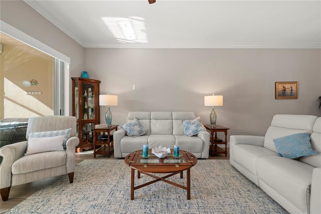 3653 Periwinkle Way, Unit 127 Naples, FL 34114 - Photo 12 of 44 a living room with furniture and a table