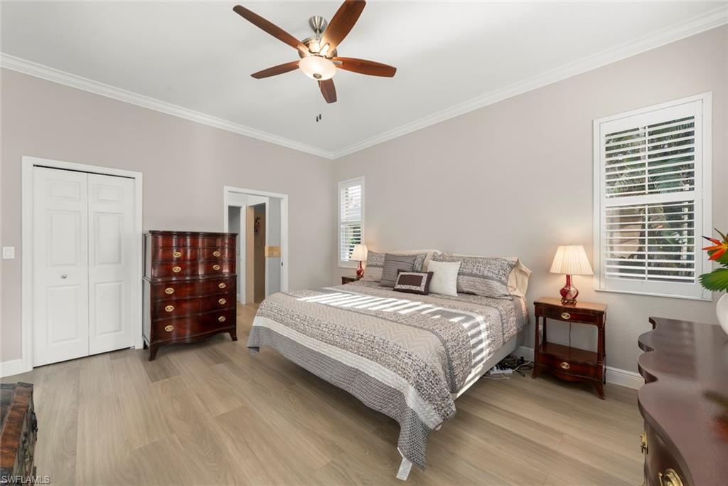 3653 Periwinkle Way, Unit 127 Naples, FL 34114 - Photo 14 of 44 a bedroom with a large bed and a chandelier