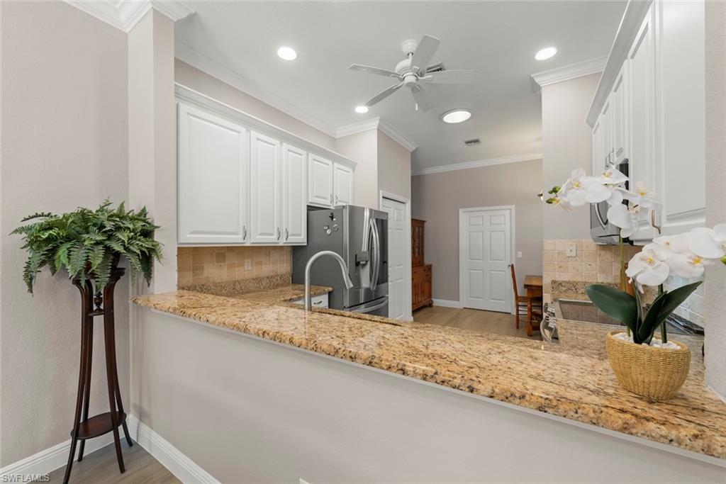 3653 Periwinkle Way, Unit 127 Naples, FL 34114 - Photo 18 of 44 a kitchen with sink and refrigerator