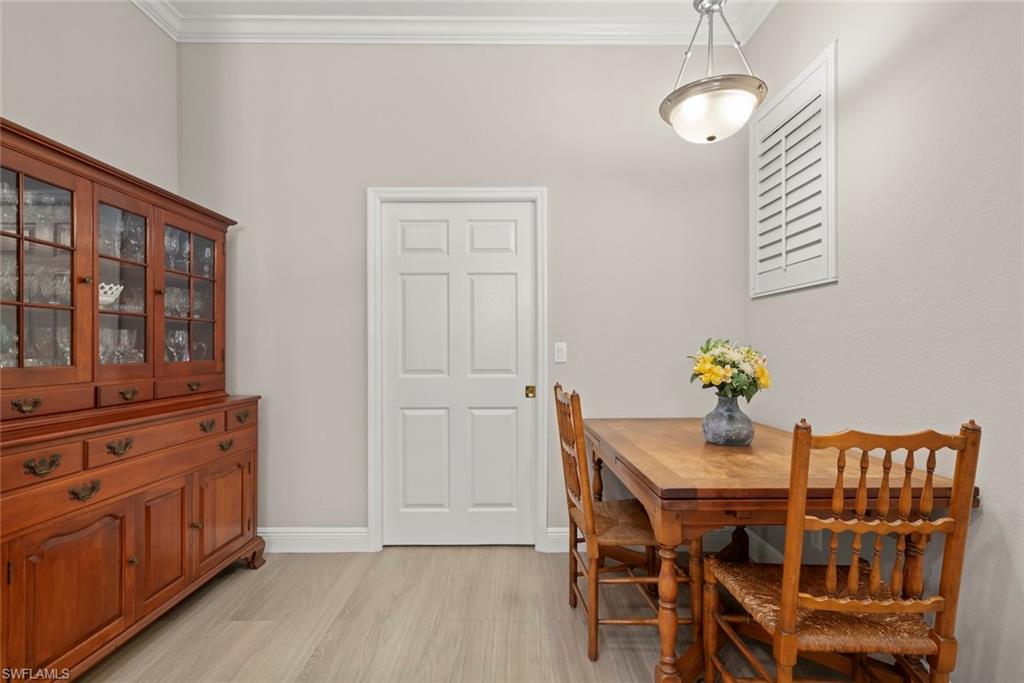 3653 Periwinkle Way, Unit 127 Naples, FL 34114 - Photo 22 of 44 a view of a dining room with furniture wooden floor and chandelier