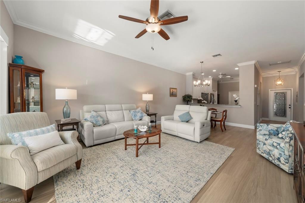 3653 Periwinkle Way, Unit 127 Naples, FL 34114 - Photo 5 of 44 a living room with furniture and a chandelier