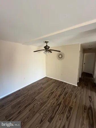 a view of a room with wooden floor and a ceiling fan