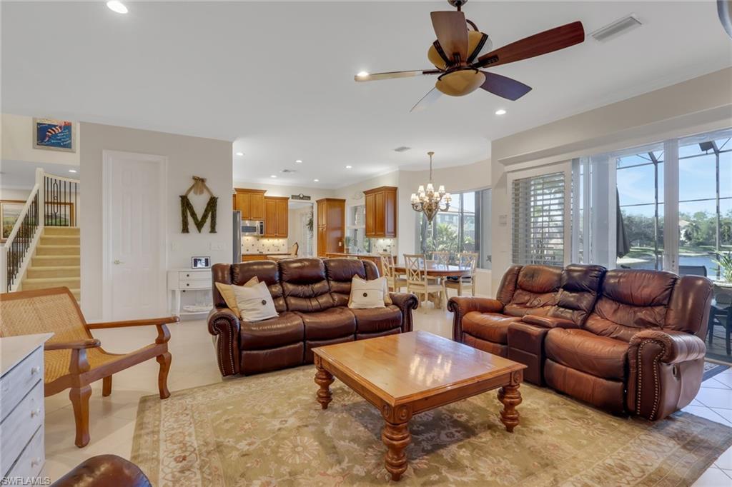 1859 Ivory Cane Point Naples, FL 34119 - Photo 18 of 50 Living room with stairway, a chandelier, ceiling fan, light tile patterned floors, and recessed lighting