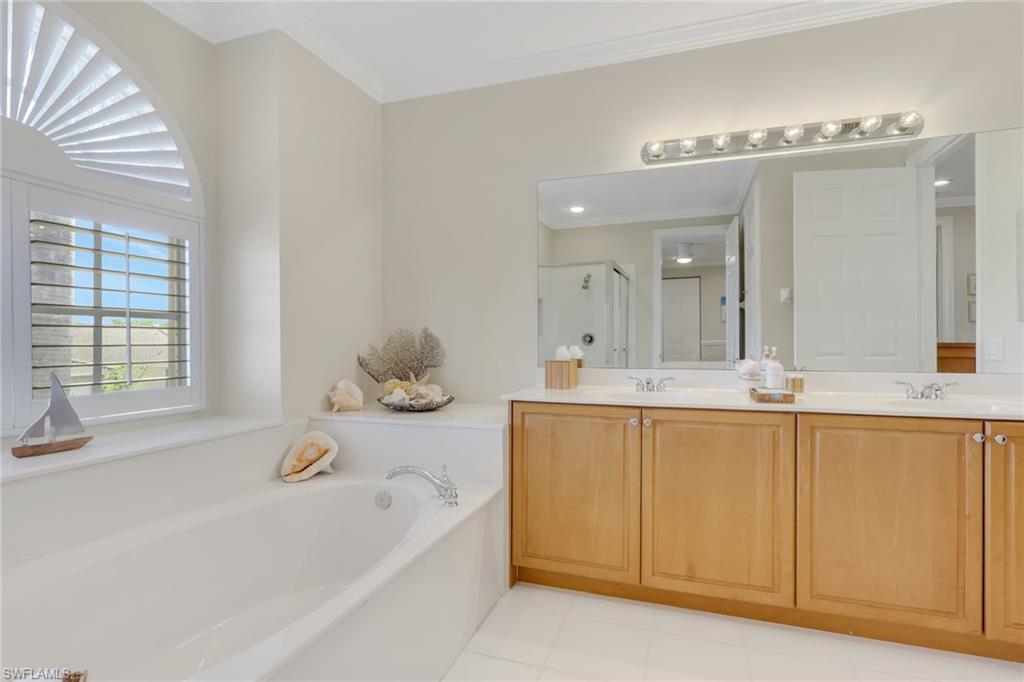 1859 Ivory Cane Point Naples, FL 34119 - Photo 20 of 50 Full bathroom featuring a garden tub, double vanity, crown molding, and a stall shower