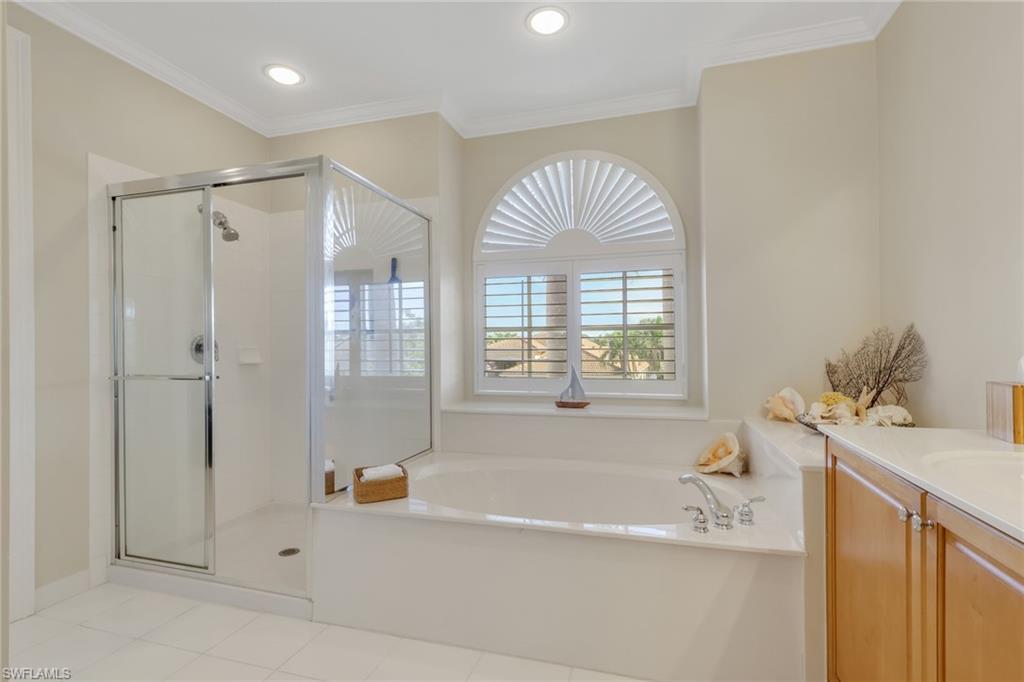 1859 Ivory Cane Point Naples, FL 34119 - Photo 21 of 50 Full bath featuring vanity, a bath, a shower stall, crown molding, and light tile patterned flooring