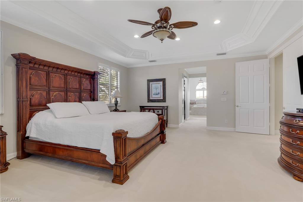 1859 Ivory Cane Point Naples, FL 34119 - Photo 28 of 50 Bedroom with light colored carpet, ornamental molding, a raised ceiling, ceiling fan, and connected bathroom