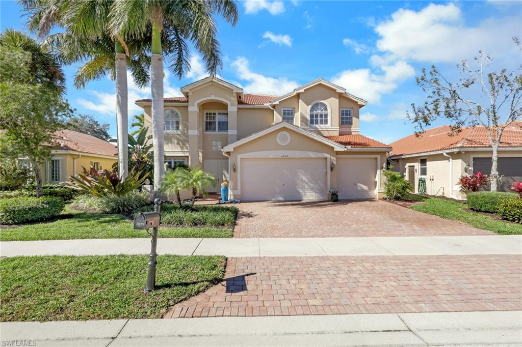 1859 Ivory Cane Point Naples, FL 34119 - Photo 3 of 50 Mediterranean / spanish-style home with a tiled roof, decorative driveway, stucco siding, a garage, and a front lawn