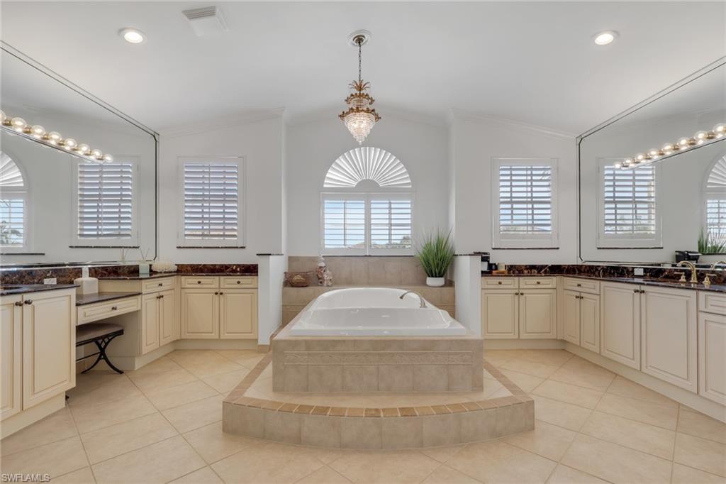 1859 Ivory Cane Point Naples, FL 34119 - Photo 33 of 50 Bathroom with two vanities, a garden tub, light tile patterned flooring, recessed lighting, and vaulted ceiling