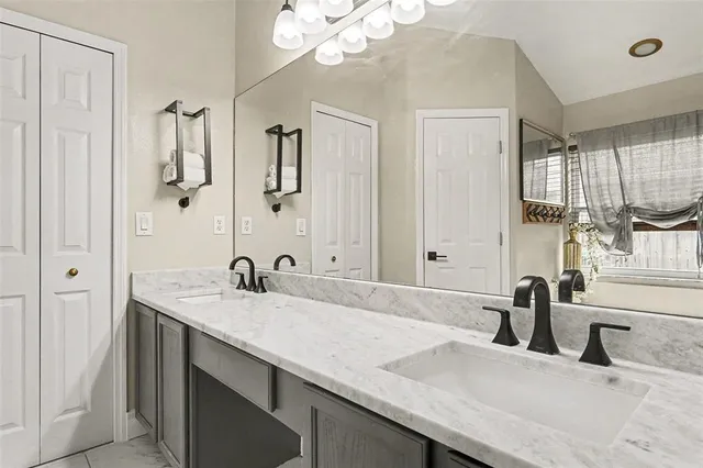 a bathroom with a granite countertop sink a large mirror and vanity
